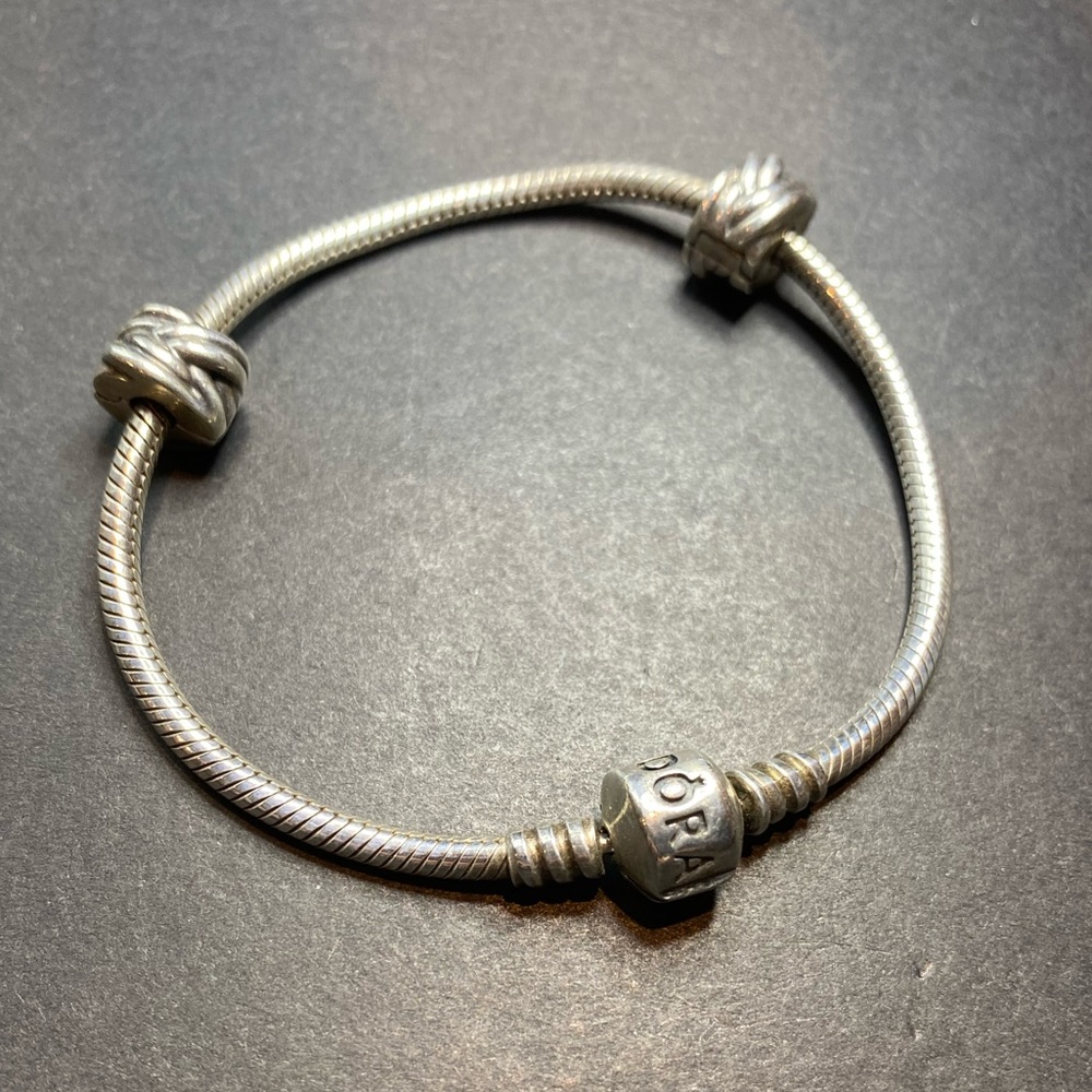 Pandora 925 bracelet with two decorative clip charms. Length shown in photo.